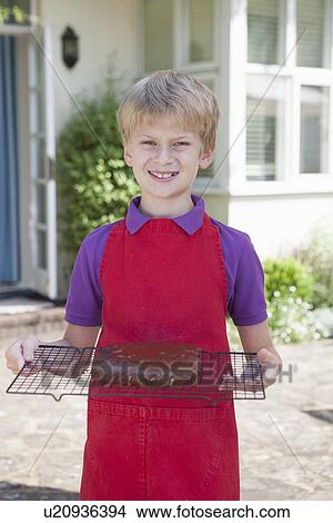 Boy holding cake on cooling tray View Large Photo Image Picture - Boy holding cake on cooling tray. Fotosearch