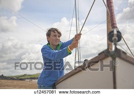 Boy pulling at sails on boat View Large Photo Image Stock Image - Boy pulling at sails on boat. Fotosearch