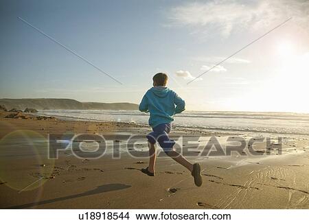 Picture - Boy running on beach. Fotosearch