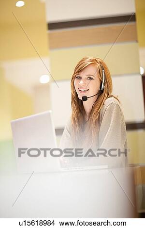 Businesswoman wearing headset in office View Large Photo Image Picture - Businesswoman wearing headset in office. Fotosearch