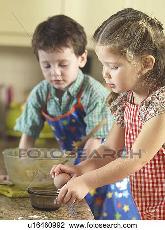 Stock Image - Children baking together in kitchen. Fotosearch