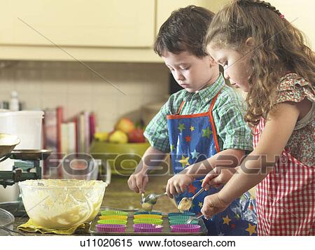 Stock Photography - Children baking together in kitchen. Fotosearch