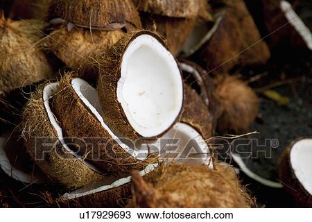 Stock Image - Close up of halved coconuts. Fotosearch