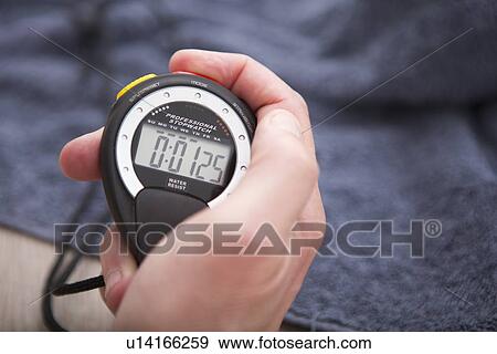 Close up of hand holding stopwatch View Large Photo Image Stock Photo - Close up of hand holding stopwatch. Fotosearch