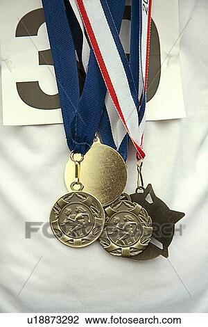 Stock Image - Close up of medals around athlete’s neck. Fotosearch
