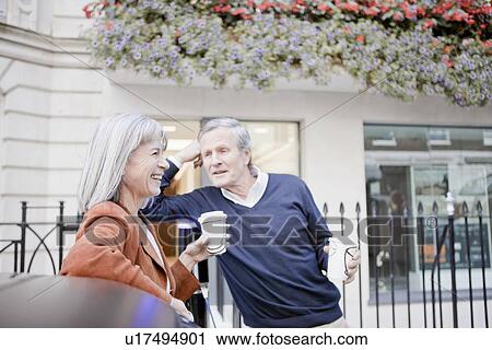 Couple drinking coffee on city street View Large Photo Image Stock Image - Couple drinking coffee on city street. Fotosearch