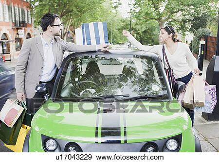 Couple loading shopping bags in car View Large Photo Image Stock Photo - Couple loading shopping bags in car. Fotosearch