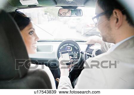 Couple using cell phone in car View Large Photo Image Stock Photo - Couple using cell phone in car. Fotosearch