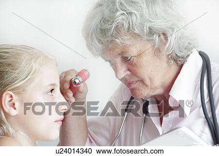 Doctor checking girl’s eyes View Large Photo Image Stock Image - Doctor checking girl’s eyes. Fotosearch