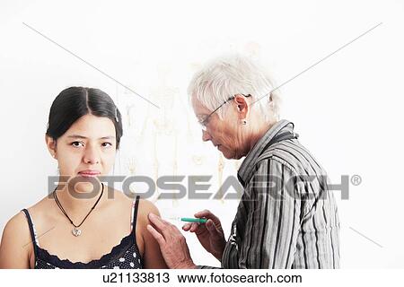 Doctor giving teenage girl shot View Large Photo Image Stock Image - Doctor giving teenage girl shot. Fotosearch