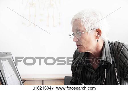 Stock Photo - Doctor using computer in office. Fotosearch