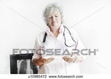 Stock Image - Doctor using tablet computer in office. Fotosearch