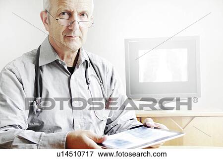 Doctor using tablet computer in office View Large Photo Image Stock Photo - Doctor using tablet computer in office. Fotosearch