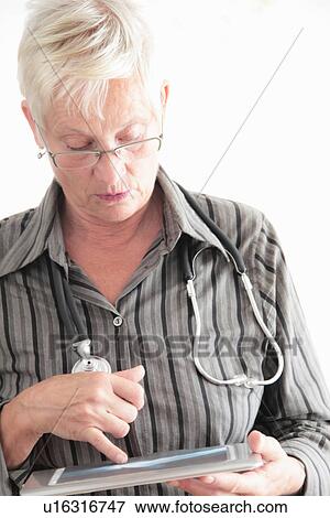 Doctor using tablet computer in office View Large Photo Image Stock Photo - Doctor using tablet computer in office. Fotosearch