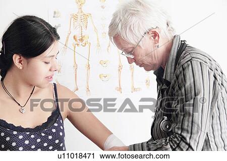 Doctor wrapping teenage girl’s elbow View Large Photo Image Stock Image - Doctor wrapping teenage girl’s elbow. Fotosearch