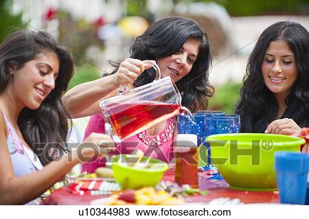 Stock Image - Family eating together outdoors. Fotosearch