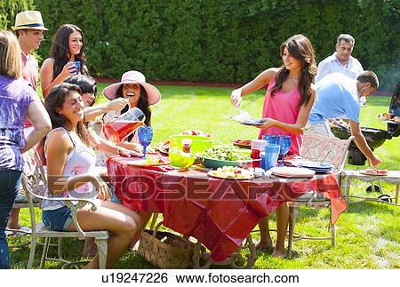 Family eating together outdoors View Large Photo Image Stock Photograph - Family eating together outdoors. Fotosearch