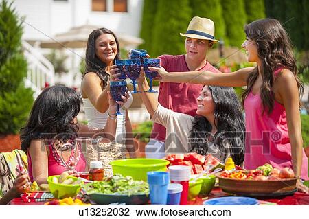 Family toasting each other outdoors View Large Photo Image Stock Image - Family toasting each other outdoors. Fotosearch