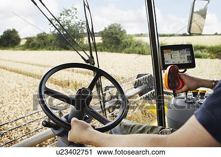 Farmer driving harvester in crop field View Large Photo Image Stock Image - Farmer driving harvester in crop field. Fotosearch