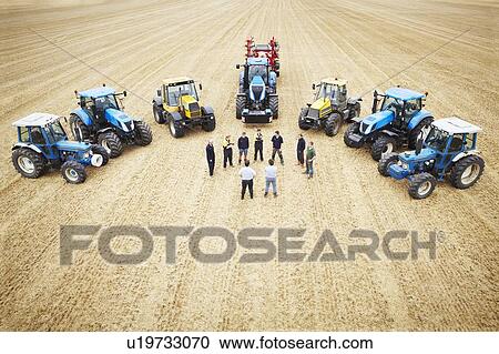 Stock Image - Farmers with tractors in crop field. Fotosearch