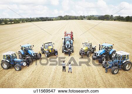 Farmers with tractors in crop field View Large Photo Image Stock Photo - Farmers with tractors in crop field. Fotosearch
