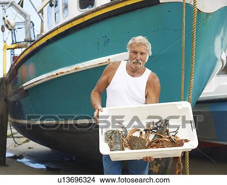 Fisherman holding catch on boat View Large Photo Image Picture - Fisherman holding catch on boat. Fotosearch
