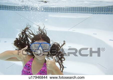 Picture - Girl giving thumbs up underwater. Fotosearch