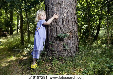 Girl hugging tree in forest View Large Photo Image Stock Image - Girl hugging tree in forest. Fotosearch