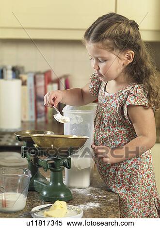 Girl weighing ingredients in kitchen View Large Photo Image Stock Photography - Girl weighing ingredients in kitchen. Fotosearch