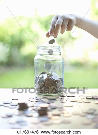 Hand tossing coins in change jar View Large Photo Image Stock Photograph - Hand tossing coins in change jar. Fotosearch