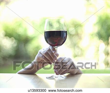 Stock Image - Hands holding stem of wine glass. Fotosearch