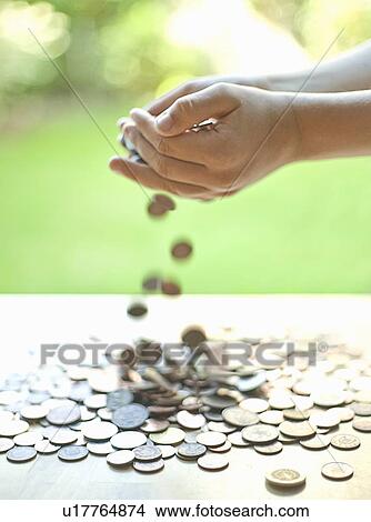 Hands pouring change on table View Large Photo Image Picture - Hands pouring change on table. Fotosearch