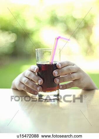 Hands reaching for glass of soda View Large Photo Image Stock Photo - Hands reaching for glass of soda. Fotosearch