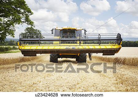 Stock Photo - Harvester working in crop field. Fotosearch