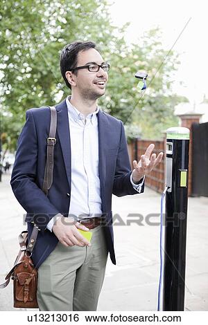 Man charging electric car on street View Large Photo Image Stock Photograph - Man charging electric car on street. Fotosearch