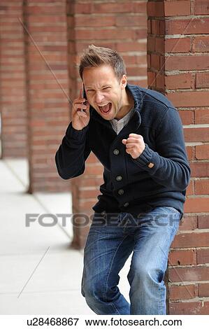 Stock Photo - Man cheering on cell phone. Fotosearch