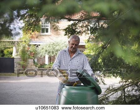 Stock Image - Man composting food scraps. Fotosearch