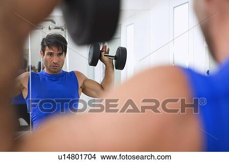 Man lifting weights in gym View Large Photo Image Picture - Man lifting weights in gym. Fotosearch