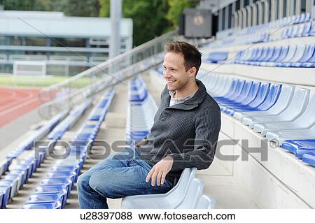 Man sitting in empty bleachers View Large Photo Image Stock Photo - Man sitting in empty bleachers. Fotosearch