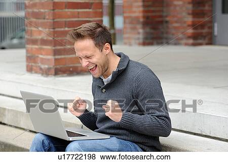 Man using laptop and cheering View Large Photo Image Stock Photo - Man using laptop and cheering . Fotosearch