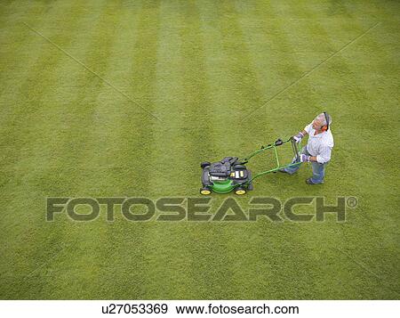 Man wearing headphones and mowing lawn View Large Photo Image Stock Photo - Man wearing headphones and mowing lawn. Fotosearch