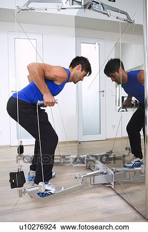 Picture - Man working out with weights in gym. Fotosearch