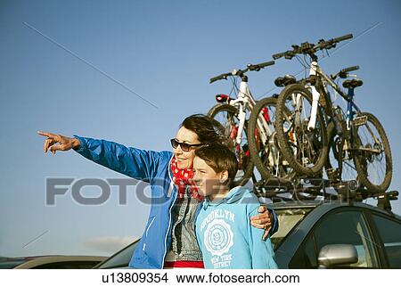 Mother and son standing by car View Large Photo Image Picture - Mother and son standing by car. Fotosearch