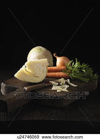 Stock Photo - Onion, carrot and cabbage on board. Fotosearch