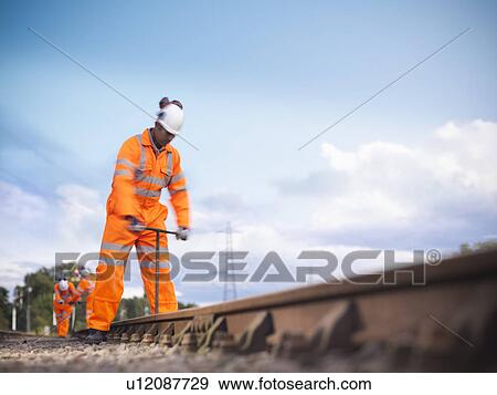 Stock Photo - Railway worker adjusting train tracks. Fotosearch
