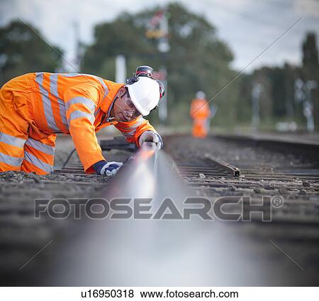 Railway worker examining train tracks View Large Photo Image Stock Photo - Railway worker examining train tracks. Fotosearch