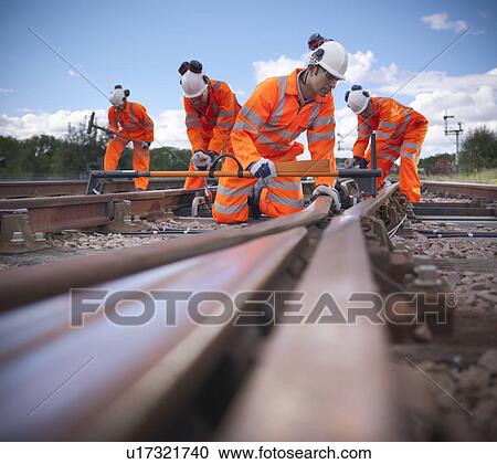 Railway workers adjusting train tracks View Large Photo Image Stock Image - Railway workers adjusting train tracks. Fotosearch