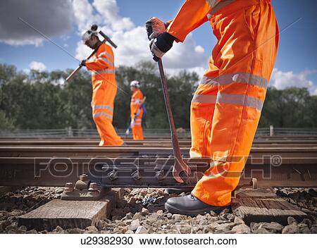 Railway workers adjusting train tracks View Large Photo Image Stock Image - Railway workers adjusting train tracks. Fotosearch