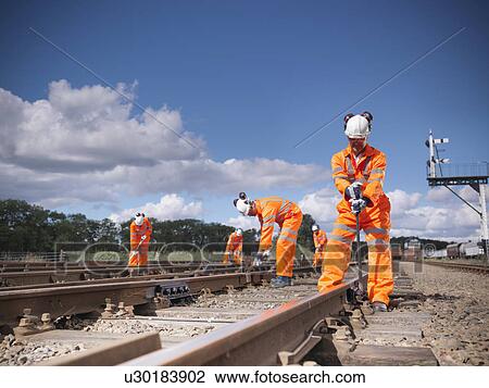 Railway workers adjusting train tracks View Large Photo Image Stock Image - Railway workers adjusting train tracks. Fotosearch