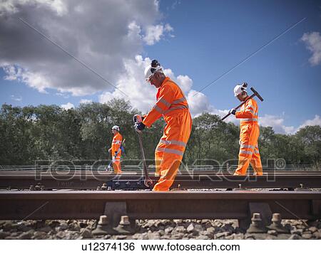 Railway workers adjusting train tracks View Large Photo Image Stock Photograph - Railway workers adjusting train tracks. Fotosearch